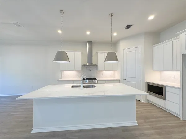 a large kitchen with kitchen island a stove a sink a refrigerator and a stove