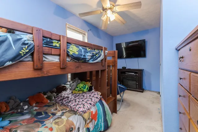 a bedroom with furniture a flat screen tv and a fireplace
