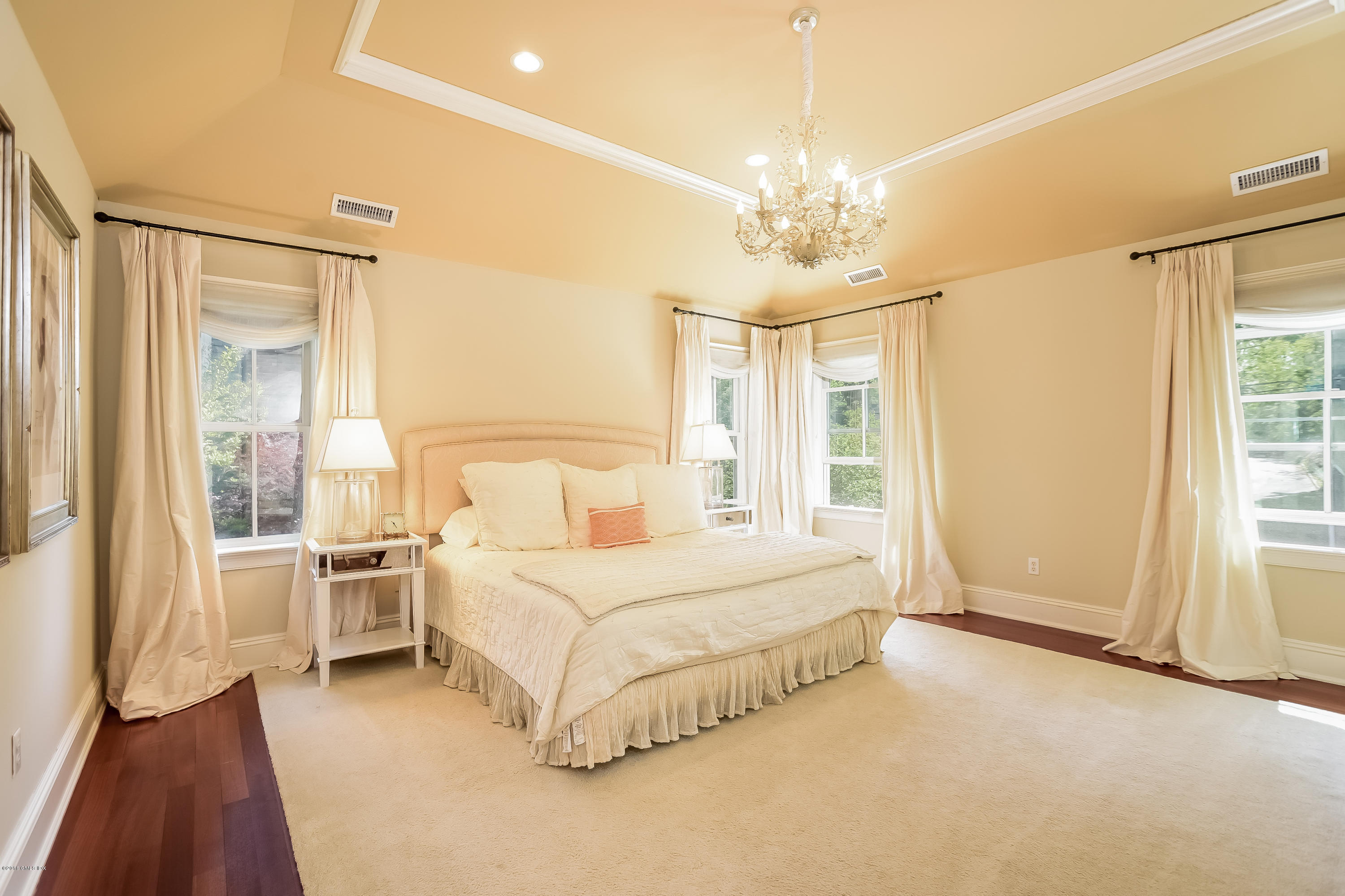 35 Lockwood Road Riverside, CT 06878 - Photo 19 of 39 a spacious bedroom with a large bed and a chandelier