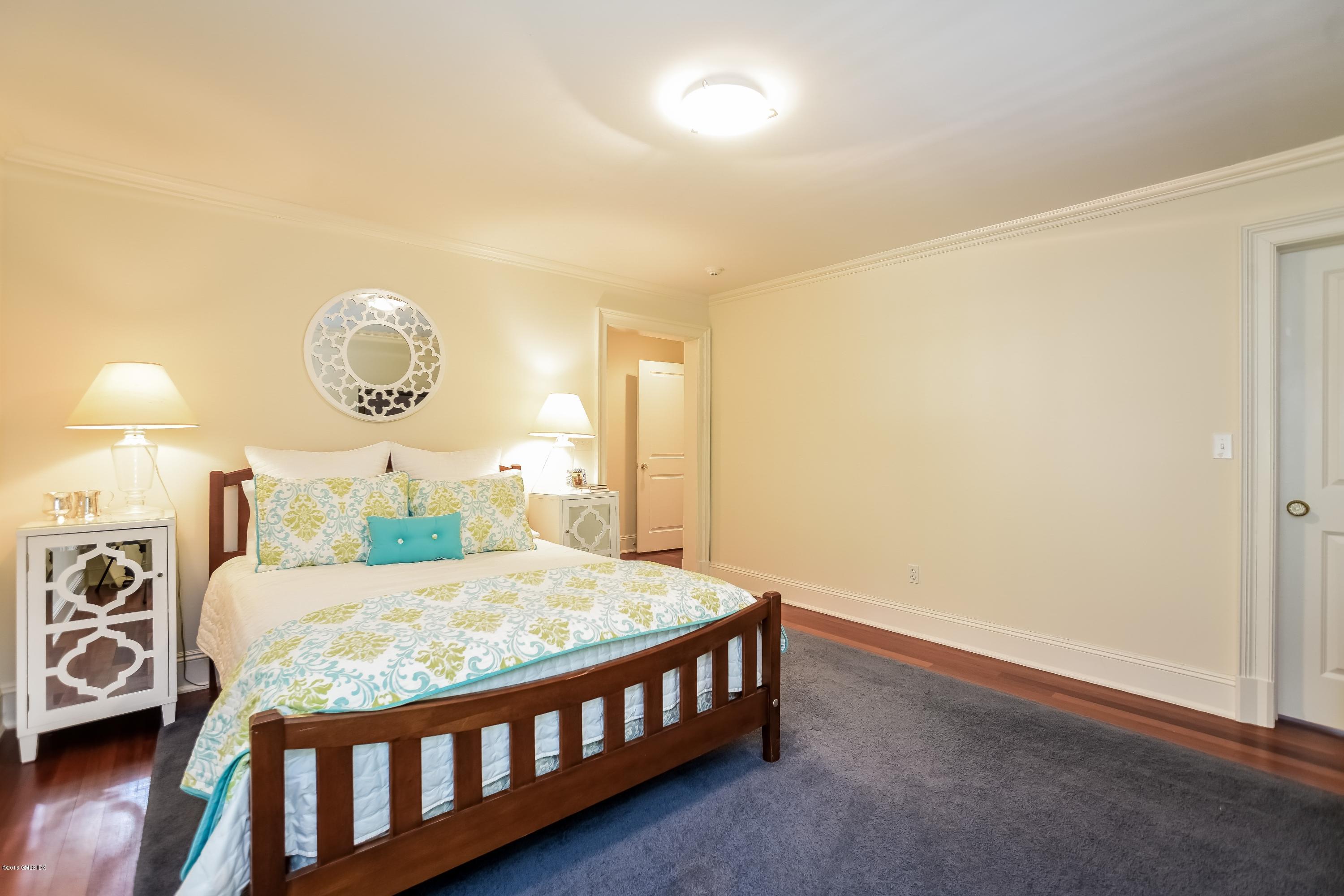 35 Lockwood Road Riverside, CT 06878 - Photo 25 of 39 a bedroom with a bed a chandelier and dresser