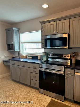 a kitchen with sink a microwave a stove and cabinets