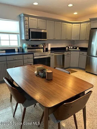 a kitchen with kitchen island wooden cabinets a sink a stove and a refrigerator