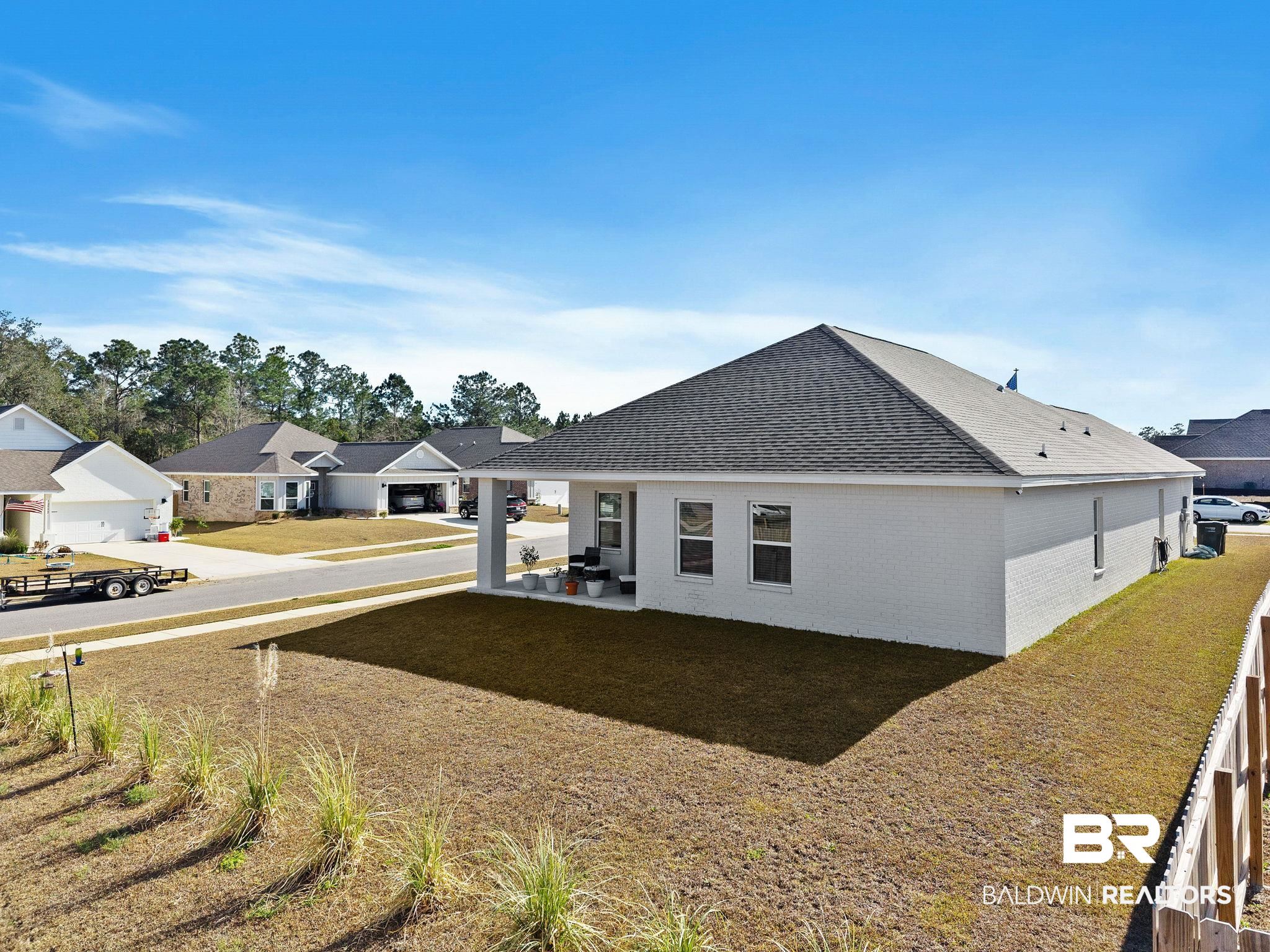12919 Torrent Road Fairhope, AL 36532 - Photo 69 of 74 Rear view of house featuring a shingled roof, brick siding, a residential view, a patio, and a yard