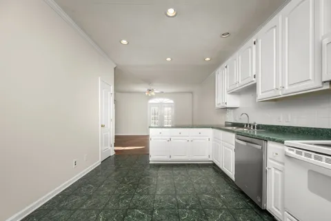 a kitchen with granite countertop white cabinets and white appliances