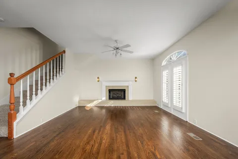 wooden floor fireplace and windows in an empty room