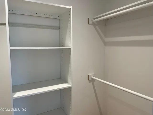 a view of walk in closet with empty racks