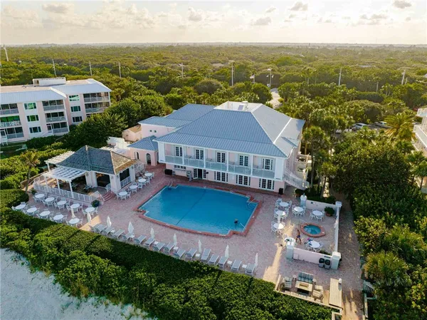 an aerial view of residential houses with outdoor space and trees