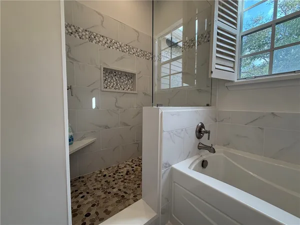 a bathroom with a bathtub and shower