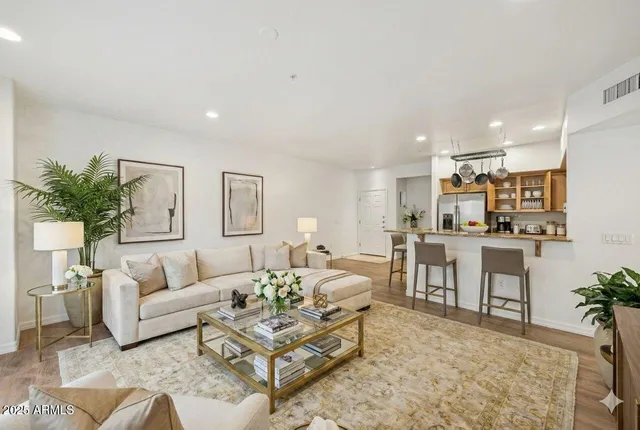 a living room with furniture and view of kitchen