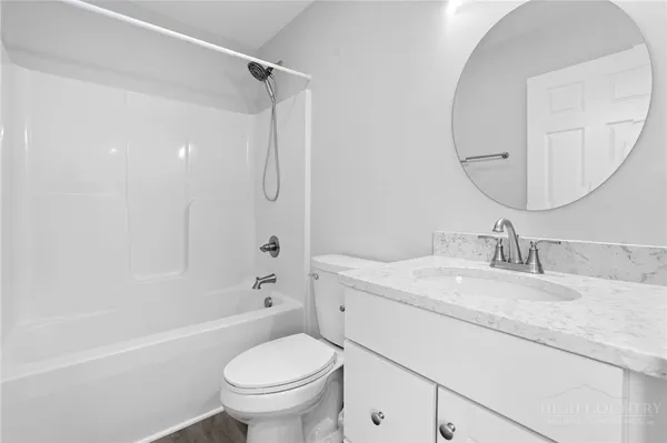 a bathroom with a granite countertop sink a toilet and a mirror
