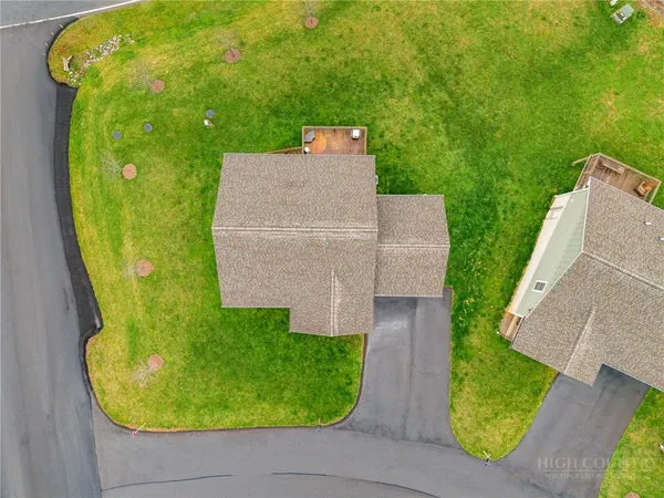 an aerial view of a house with swimming pool and large trees