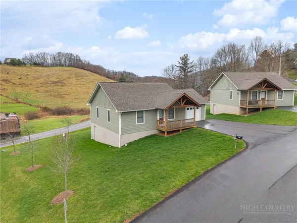 a view of a house with a big yard and large trees