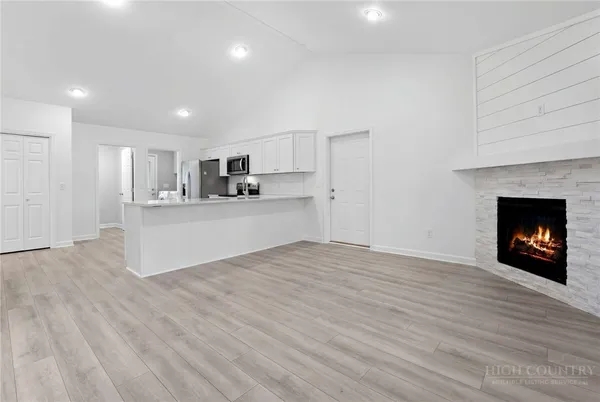 a view of a kitchen with a sink a fireplace and wooden floor