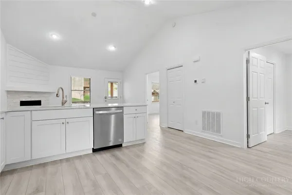 a kitchen with white cabinets and stainless steel appliances