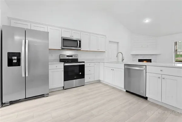 a kitchen with white cabinets stainless steel appliances and sink