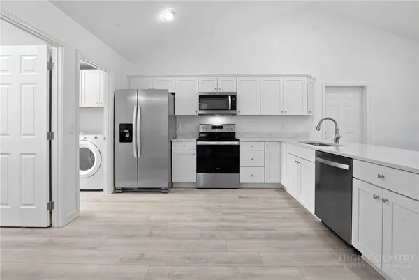 a kitchen with stainless steel appliances a refrigerator sink and cabinets