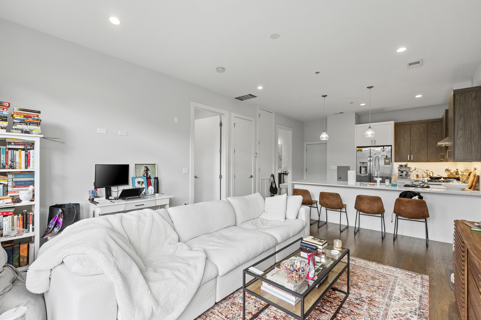 2217 West Madison Street, Unit 414 Chicago, IL 60612 - Photo 3 of 17 a living room with furniture a flat screen tv and a bookshelf