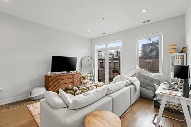 a living room with furniture a flat screen tv and a large window