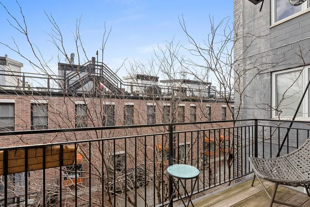 a view of a balcony that has two chairs and a table