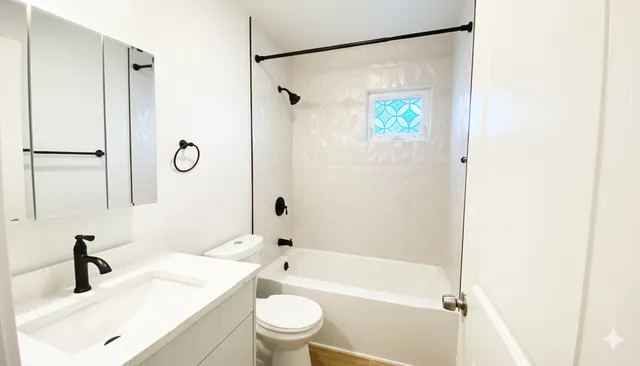 a bathroom with a granite countertop sink toilet and shower