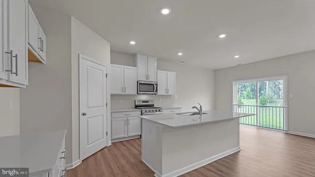 a kitchen with stainless steel appliances a sink stove and cabinets