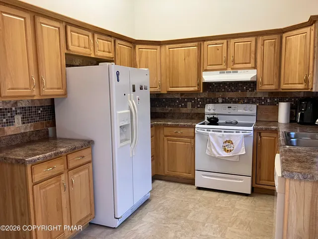a kitchen with a stove a sink and a refrigerator