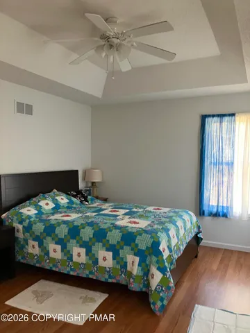 a bedroom with a bed that has a blanket and a chair