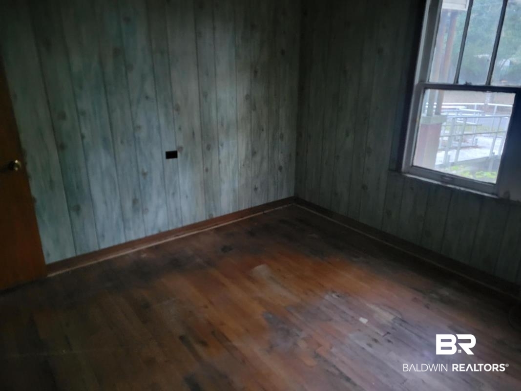 2059 Magnolia Lane Mobile, AL 36605 - Photo 15 of 17 Unfurnished room with dark wood finished floors and baseboards