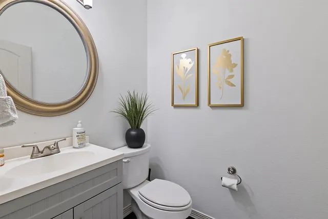 a bathroom with a toilet a sink and mirror