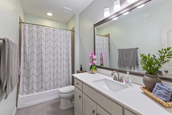a bathroom with a granite countertop sink a toilet and a mirror