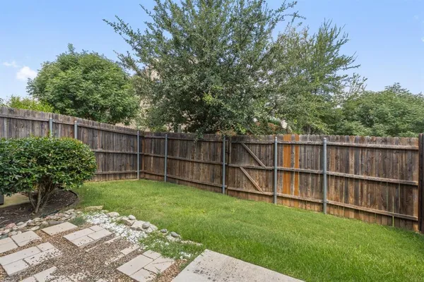 a view of a backyard with a wooden fence