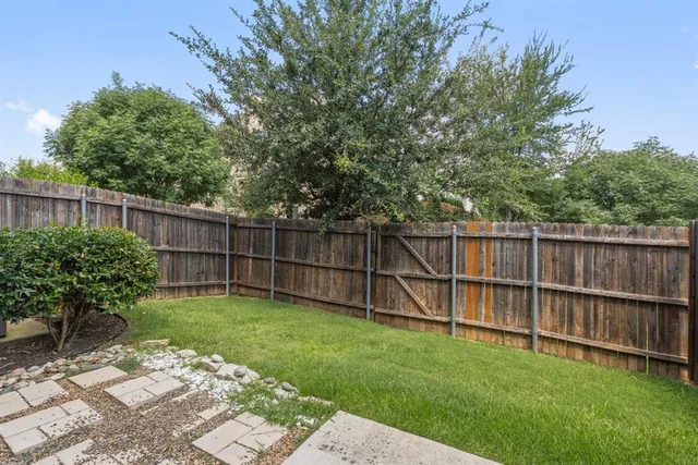 a view of a backyard with a wooden fence