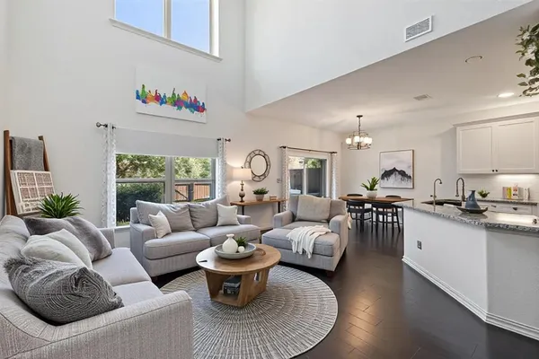 a living room with furniture kitchen view and a large window