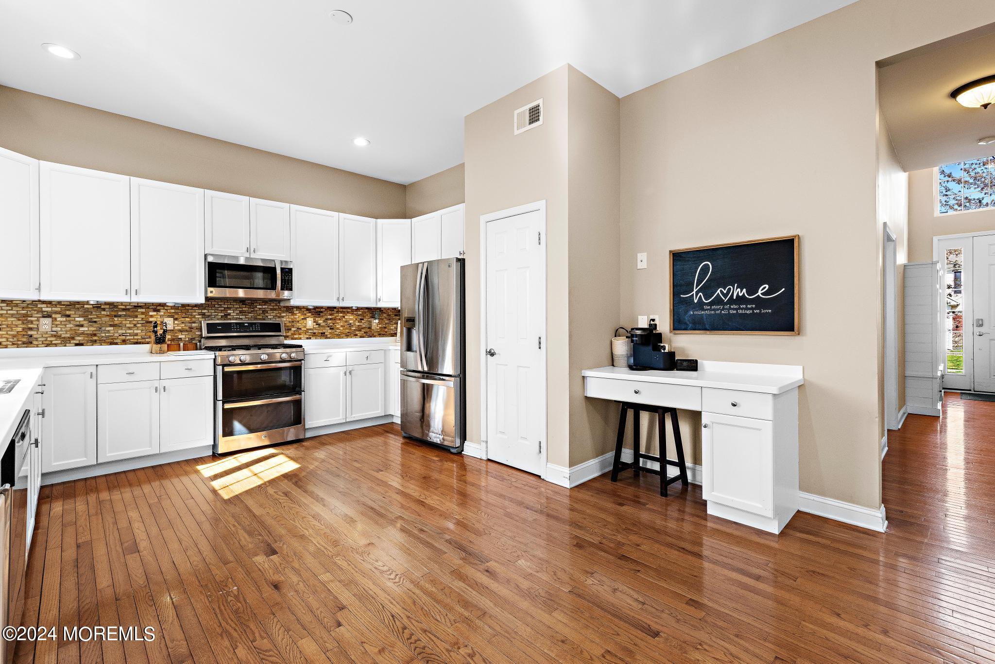25 Firestone Drive Howell, NJ 07731 - Photo 11 of 65 a kitchen with white cabinets and stainless steel appliances