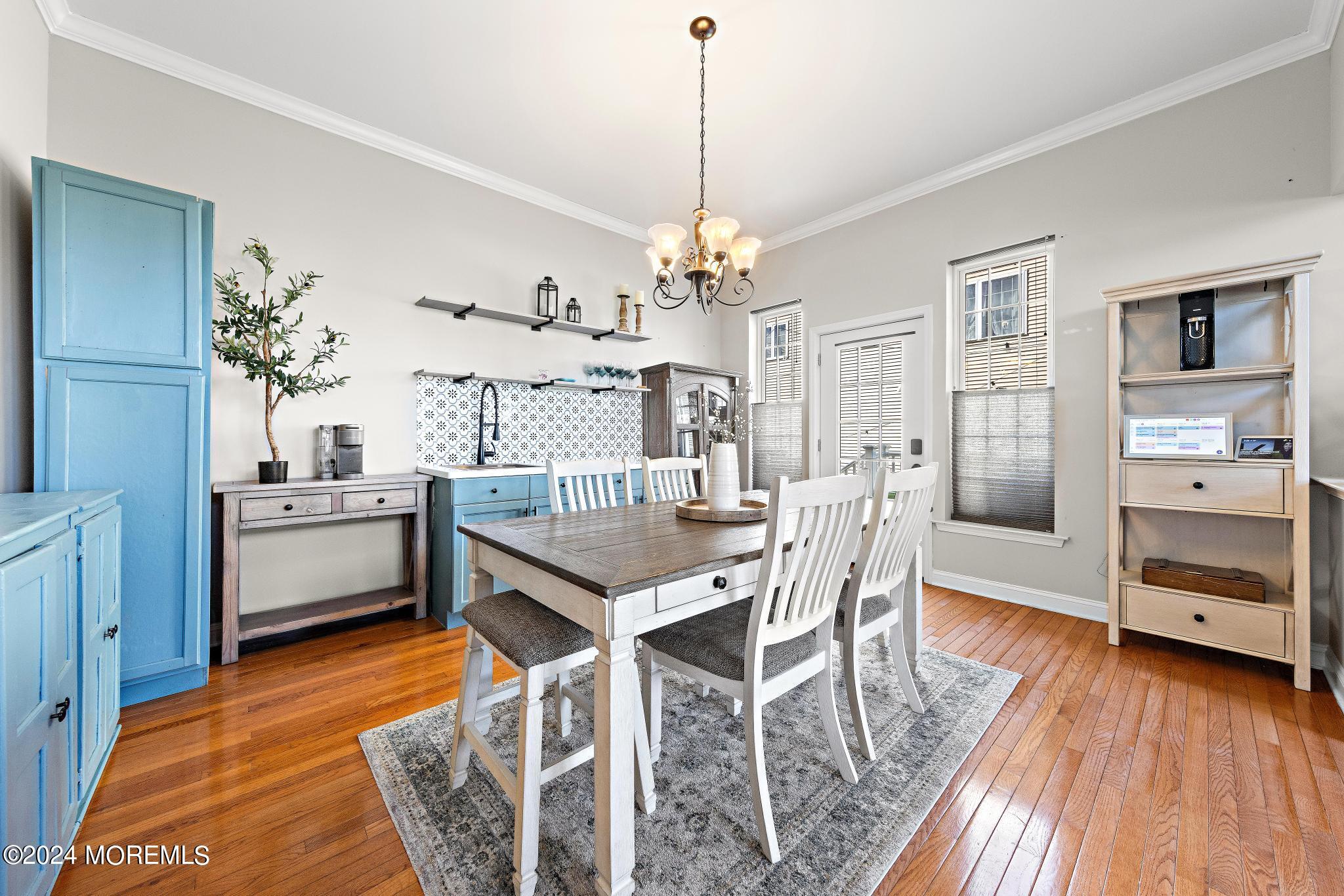 25 Firestone Drive Howell, NJ 07731 - Photo 18 of 65 a dining room with wooden floor a chandelier a wooden table and chairs
