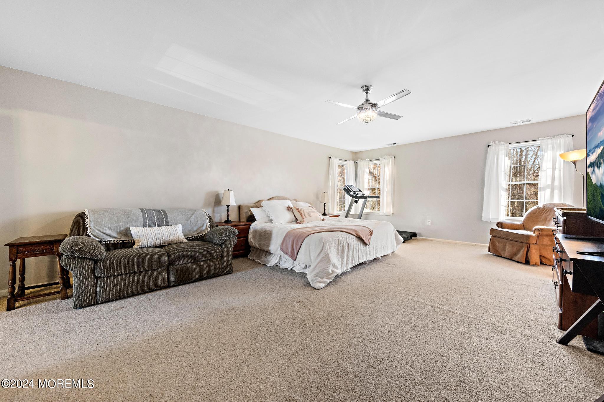 25 Firestone Drive Howell, NJ 07731 - Photo 24 of 65 a spacious bedroom with a bed a couch and a chandelier