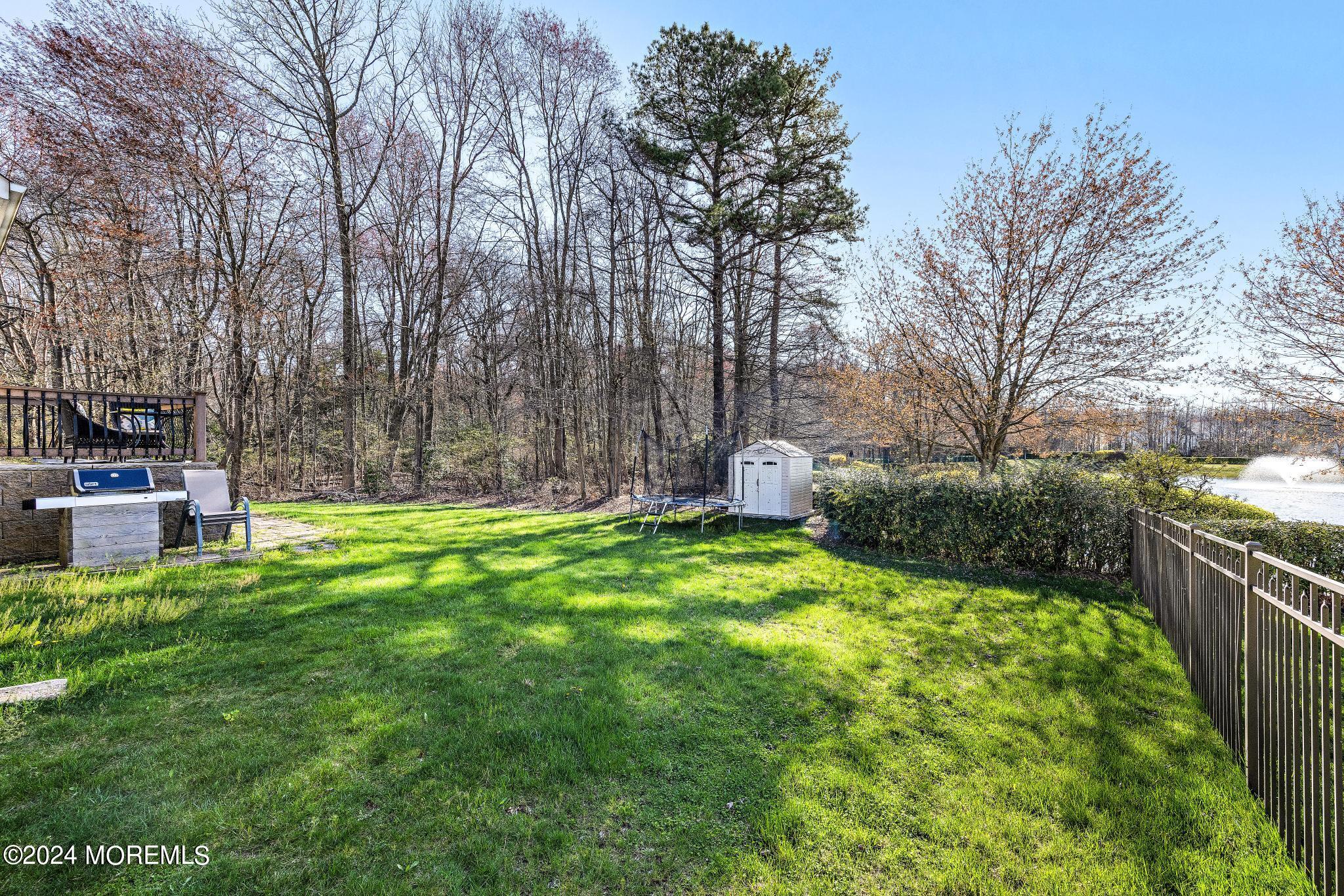 25 Firestone Drive Howell, NJ 07731 - Photo 46 of 65 a view of a backyard with table and chairs wooden fence
