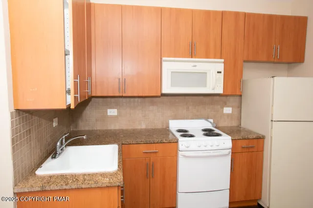 a kitchen with a sink a stove and a microwave