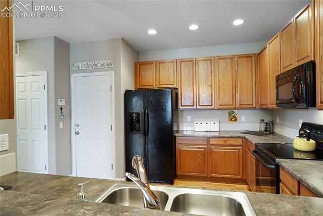 3912 Diamond Ridge View Colorado Springs, CO 80918 - Photo 8 of 31 2 car attached garage is accessed through kitchen. Kitchen is open to family room with breakfast bar.