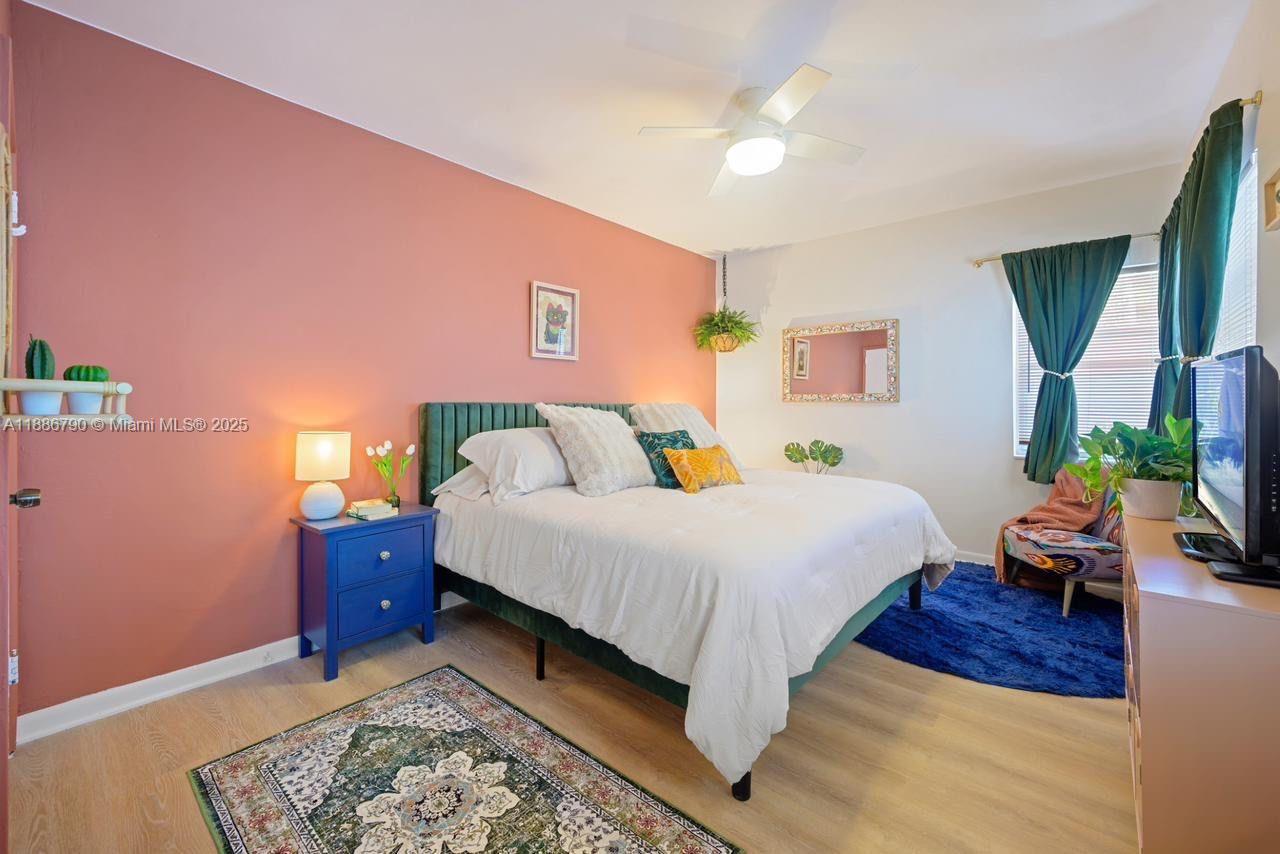 315 Van Buren Street, Unit 104B Hollywood, FL 33019 - Photo 11 of 22 a spacious bedroom with a bed and a chandelier