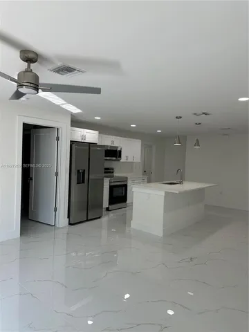 a large bathroom with a large mirror and stainless steel appliances
