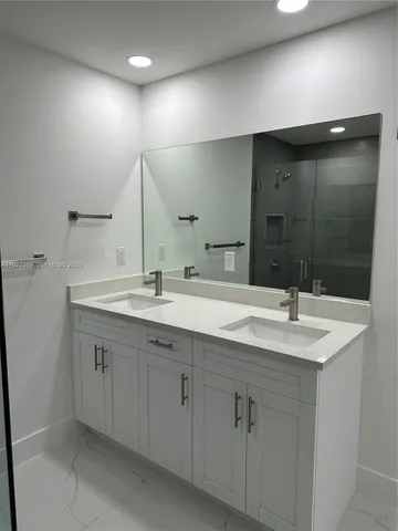 a bathroom with a double vanity sink and mirror