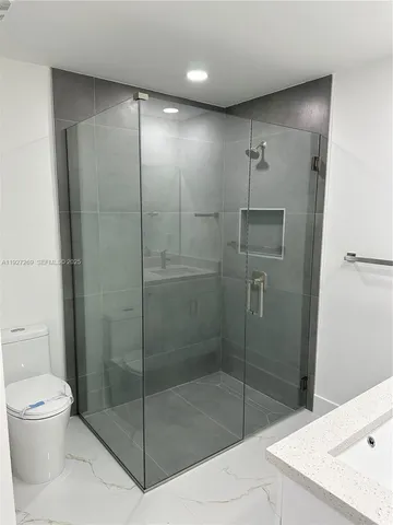 a bathroom with a shower a toilet and sink