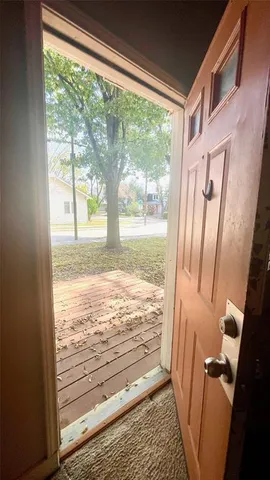 a view of a room with wooden floor and front door