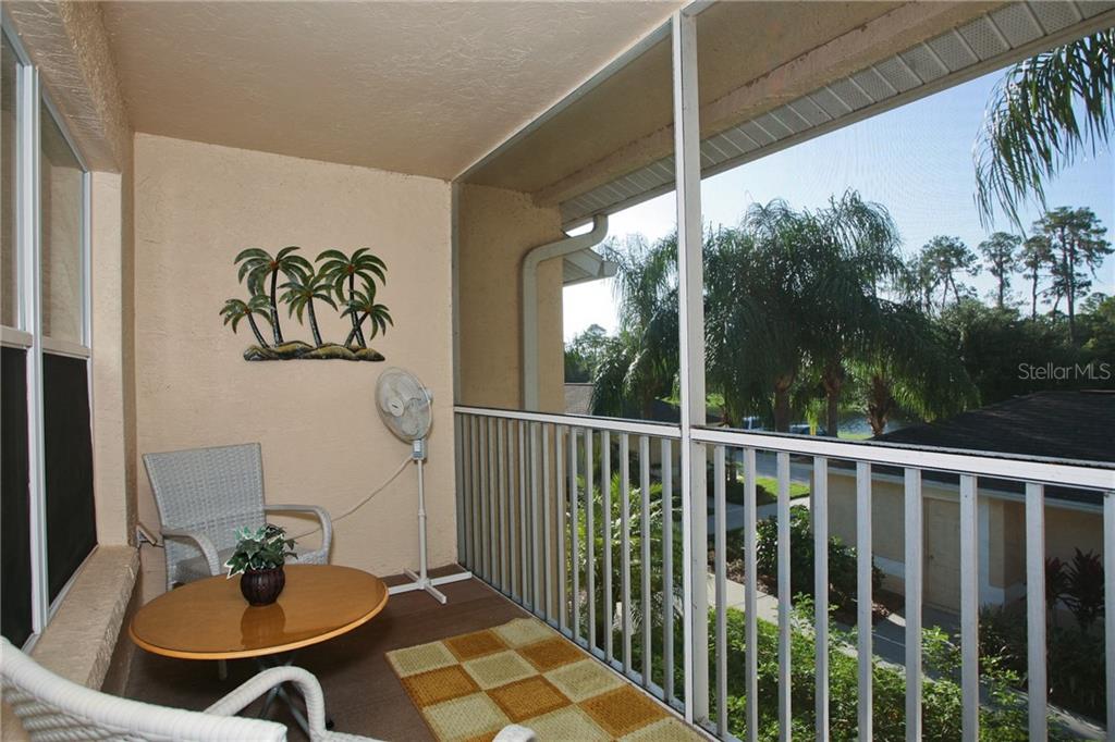 5270 Hyland Hills Avenue, Unit 1722 Sarasota, FL 34241 - Photo 13 of 30 a balcony view with couple of chairs and potted plant