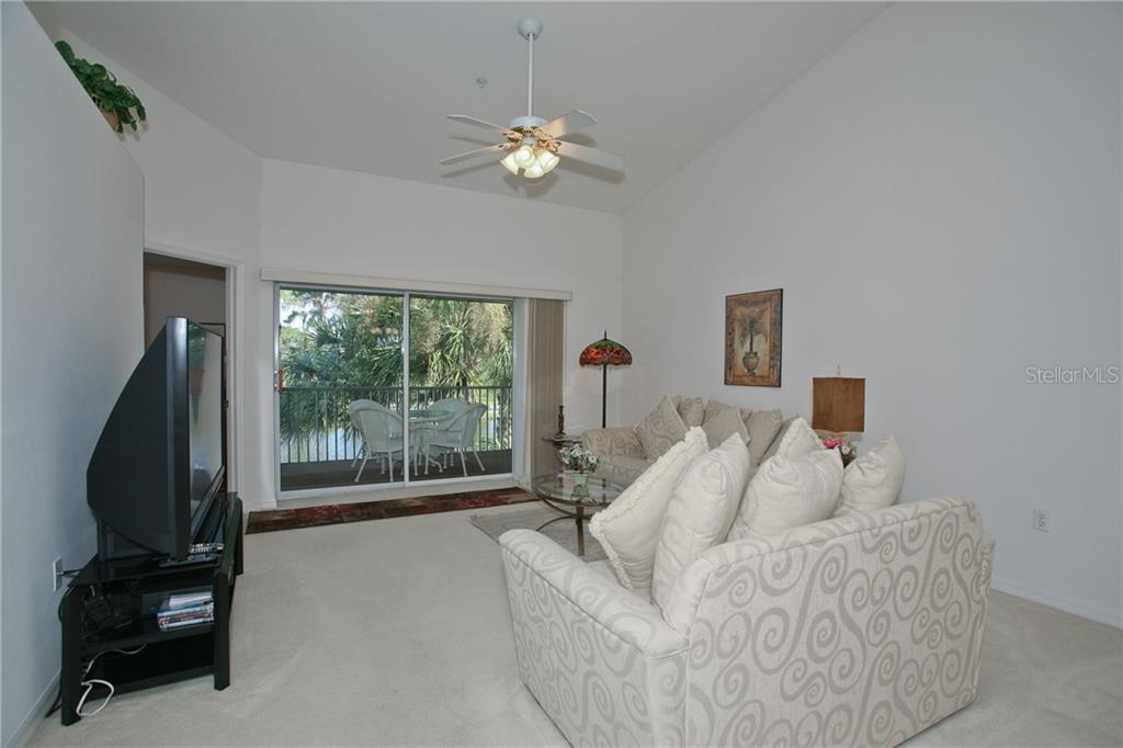 5270 Hyland Hills Avenue, Unit 1722 Sarasota, FL 34241 - Photo 16 of 30 a living room with furniture and a flat screen tv