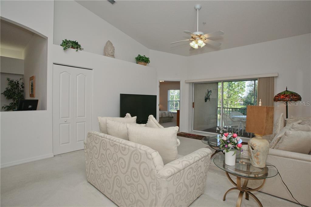 5270 Hyland Hills Avenue, Unit 1722 Sarasota, FL 34241 - Photo 17 of 30 a living room with furniture and a flat screen tv