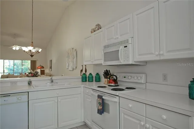 a kitchen with white cabinets and white appliances