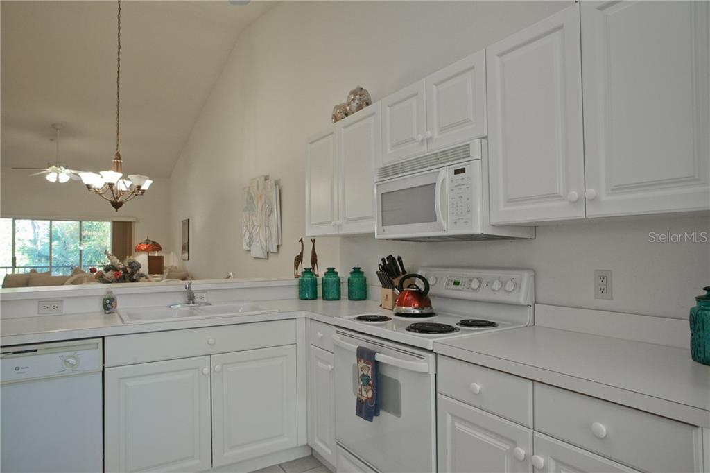 5270 Hyland Hills Avenue, Unit 1722 Sarasota, FL 34241 - Photo 19 of 30 a kitchen with white cabinets and a sink