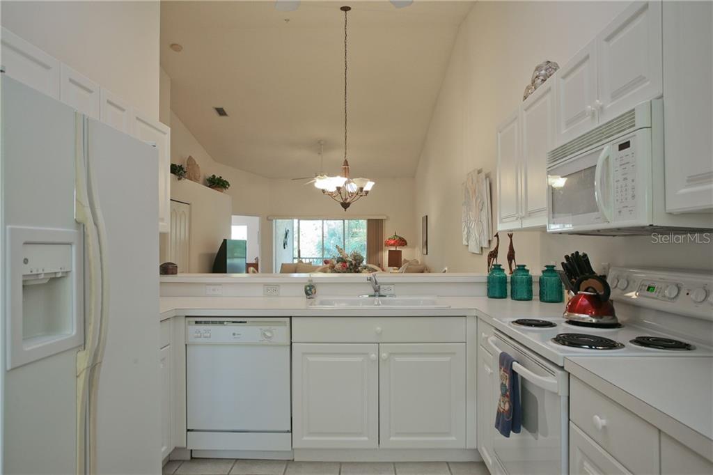 5270 Hyland Hills Avenue, Unit 1722 Sarasota, FL 34241 - Photo 20 of 30 a kitchen with white cabinets and white appliances